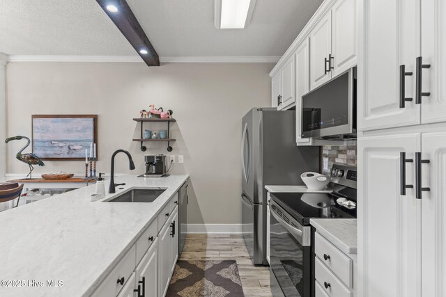 kitchen with decorative light fixtures, sink, light stone counters, crown molding, and a textured ceiling