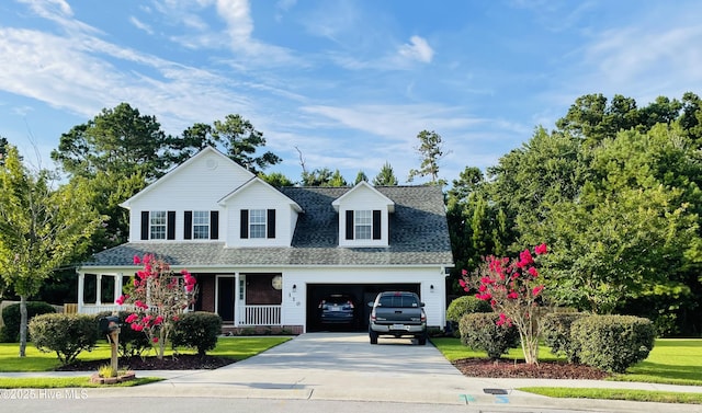 view of front of house featuring a garage, covered porch, a shingled roof, and concrete driveway