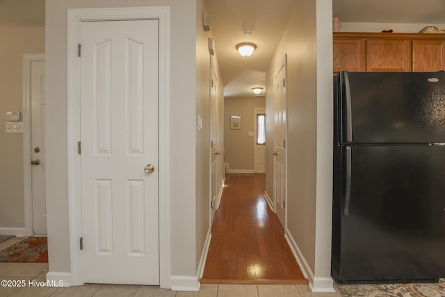 hall with baseboards and light tile patterned floors