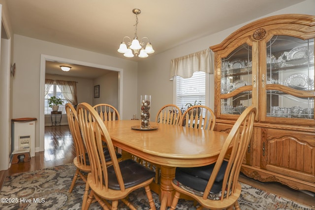 dining area with baseboards, dark wood finished floors, and a notable chandelier