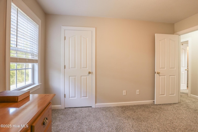 unfurnished bedroom with light carpet and baseboards