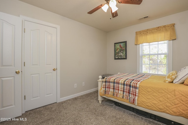 carpeted bedroom featuring a ceiling fan, visible vents, and baseboards