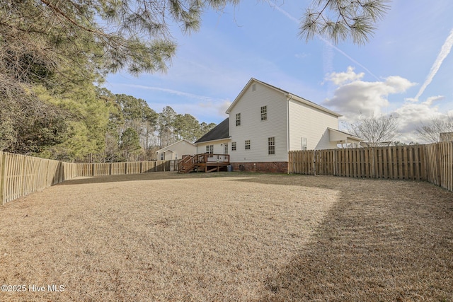 rear view of house with a fenced backyard and a deck