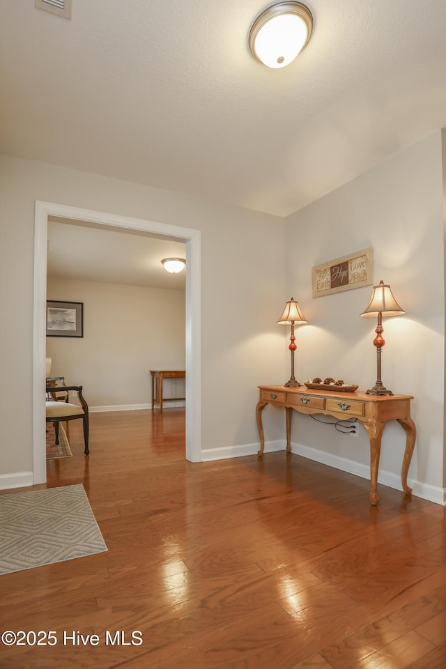 interior space with wood finished floors and baseboards