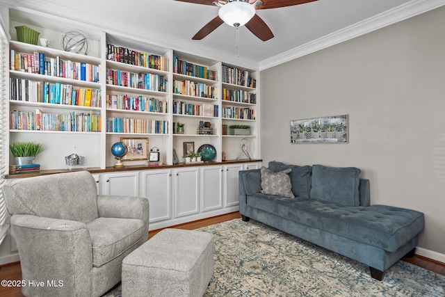 living area featuring hardwood / wood-style flooring, ceiling fan, and crown molding