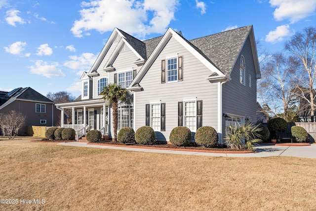 view of front of house with a garage, a porch, and a front yard