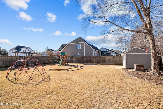 view of yard with a storage shed and a playground