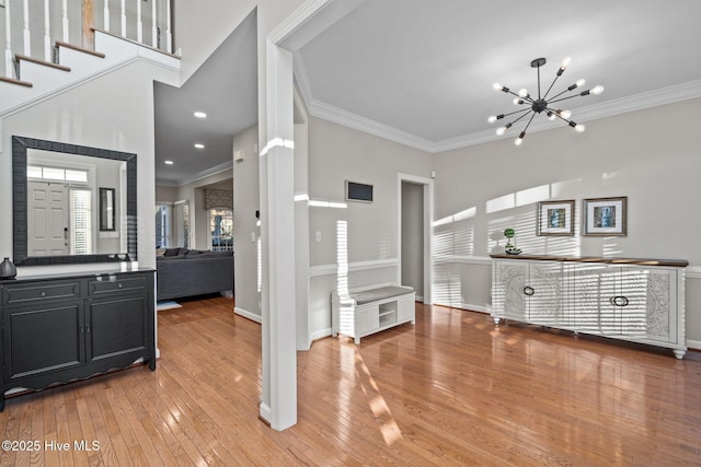 interior space featuring crown molding, a notable chandelier, and light hardwood / wood-style floors