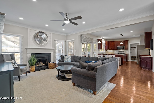 living room with ceiling fan, ornamental molding, and dark hardwood / wood-style floors