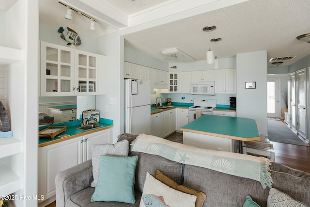 kitchen featuring white cabinetry, white appliances, sink, and a textured ceiling