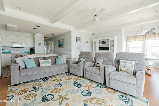 living room with beamed ceiling, ceiling fan, and light wood-type flooring