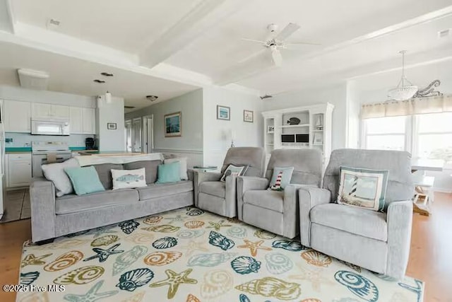 living room featuring beam ceiling, light hardwood / wood-style floors, and ceiling fan