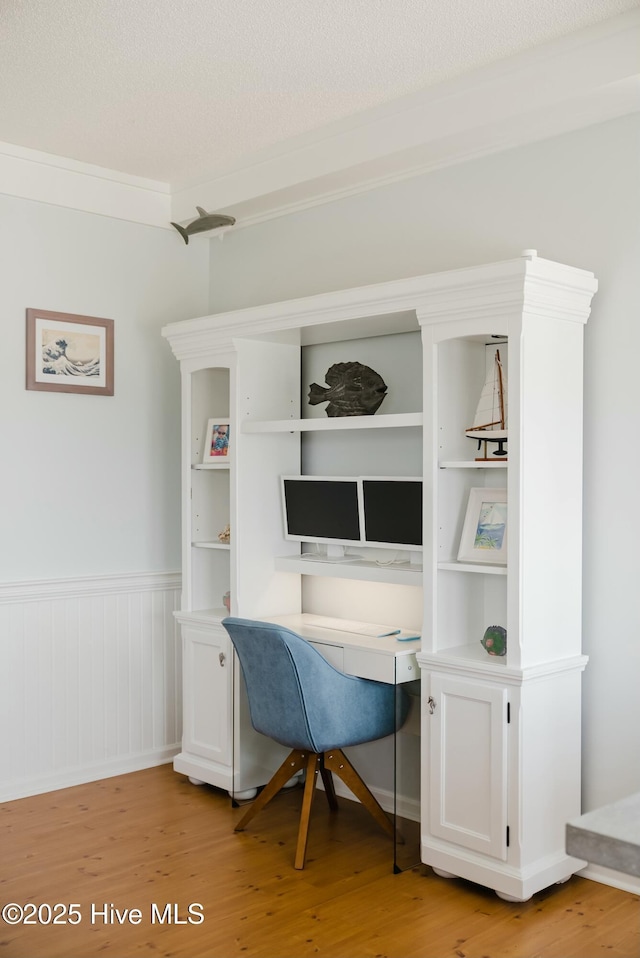 office space featuring ornamental molding, a textured ceiling, and light wood-type flooring