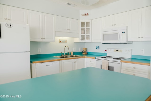 kitchen with sink, white appliances, and white cabinets