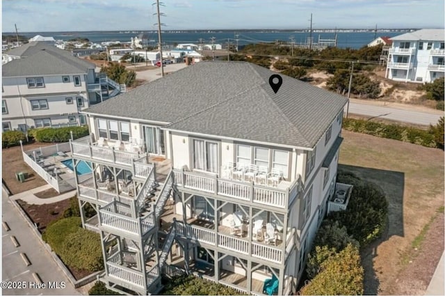 exterior space featuring a balcony and a water view