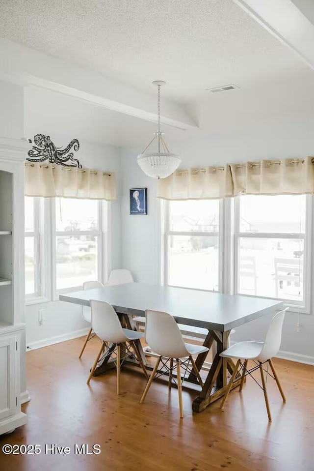 dining area with hardwood / wood-style floors and a textured ceiling