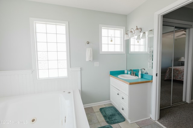 bathroom with vanity, a wealth of natural light, tile patterned floors, and a bathtub