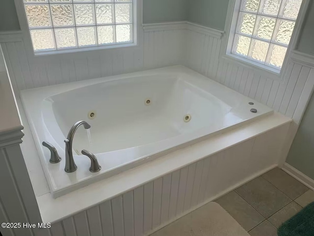 bathroom featuring a relaxing tiled tub and tile patterned floors