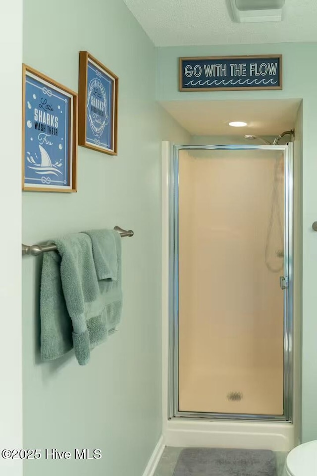 bathroom with an enclosed shower and toilet