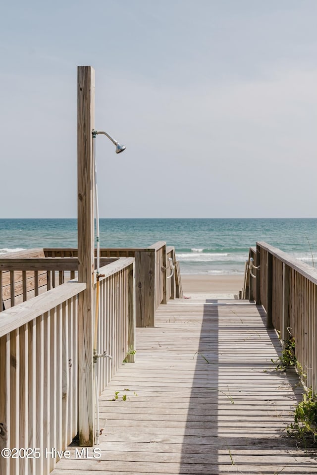 view of community featuring a water view and a beach view