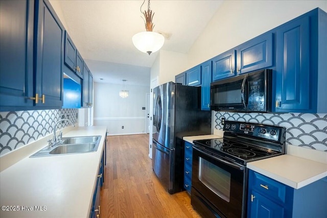 kitchen featuring hanging light fixtures, blue cabinetry, sink, and black appliances