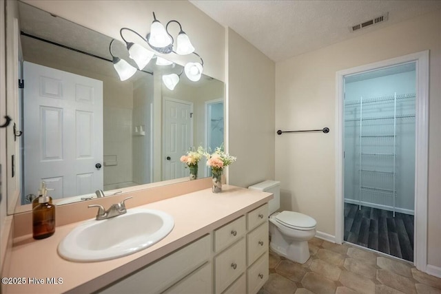 bathroom with vanity, a textured ceiling, and toilet