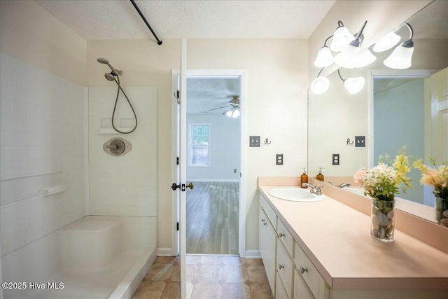 bathroom with a shower, tile patterned flooring, vanity, ceiling fan, and a textured ceiling