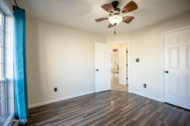 unfurnished bedroom featuring ceiling fan and dark hardwood / wood-style flooring