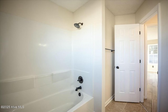 bathroom featuring tile patterned floors and bathing tub / shower combination