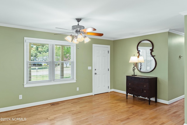 foyer with ornamental molding, plenty of natural light, and light wood-type flooring