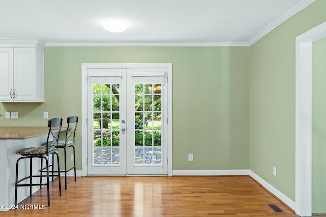 doorway to outside with crown molding, french doors, and light hardwood / wood-style flooring