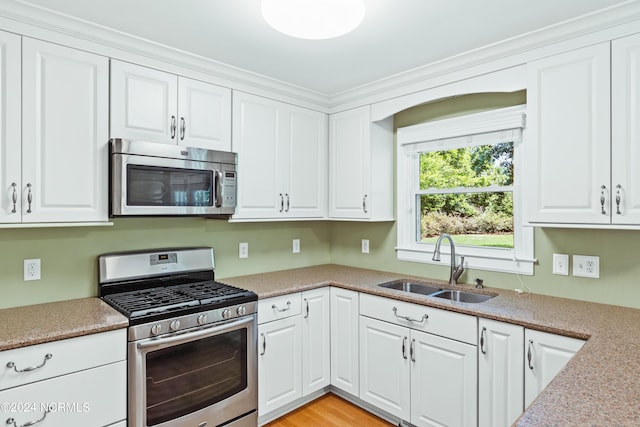 kitchen featuring stainless steel appliances, sink, and white cabinets