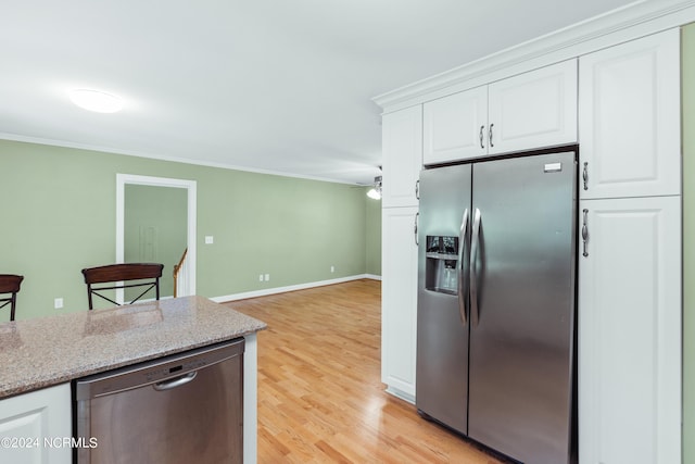 kitchen with white cabinetry, appliances with stainless steel finishes, crown molding, and light stone counters