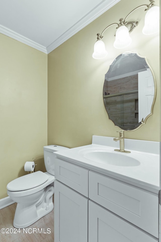 bathroom with crown molding, vanity, and toilet