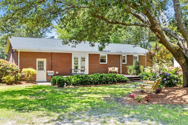 rear view of house featuring a lawn and a deck