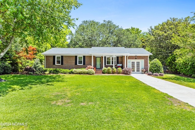 ranch-style house featuring french doors, a porch, and a front lawn