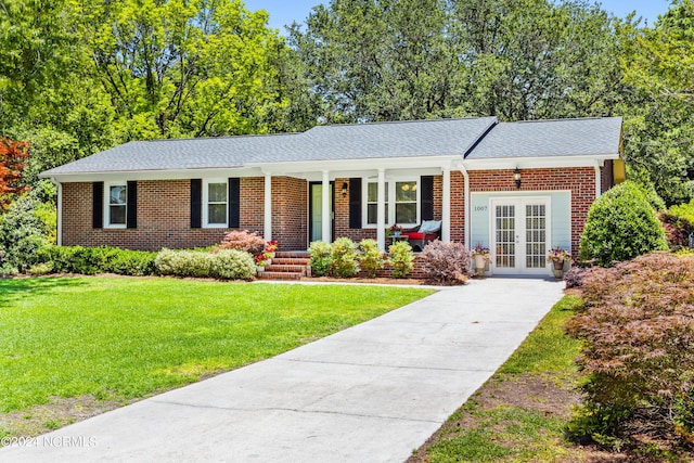 ranch-style house with a front lawn, covered porch, and french doors