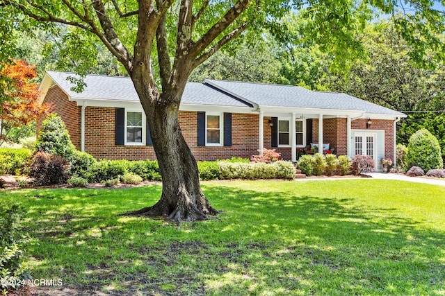 single story home with french doors, covered porch, and a front yard