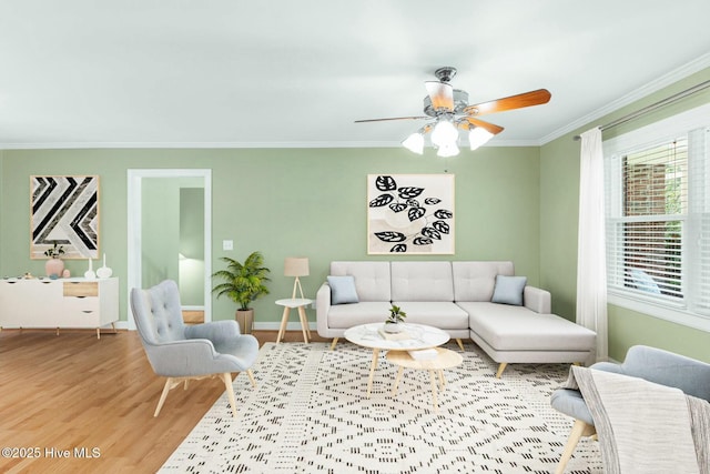 living room with ornamental molding, wood-type flooring, and ceiling fan