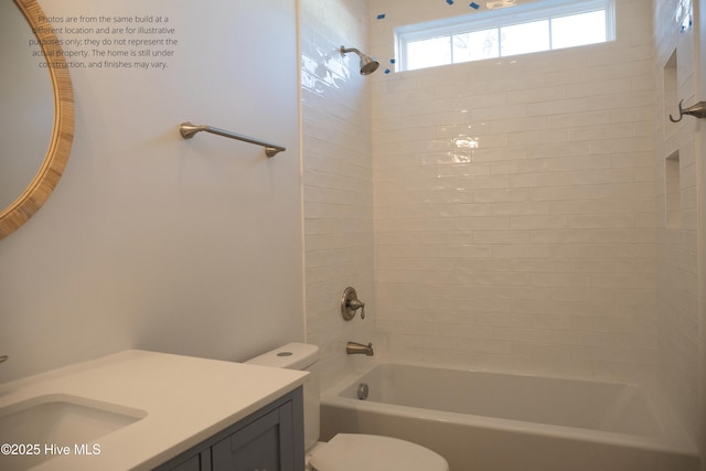 full bathroom with vanity, tiled shower / bath combo, and toilet