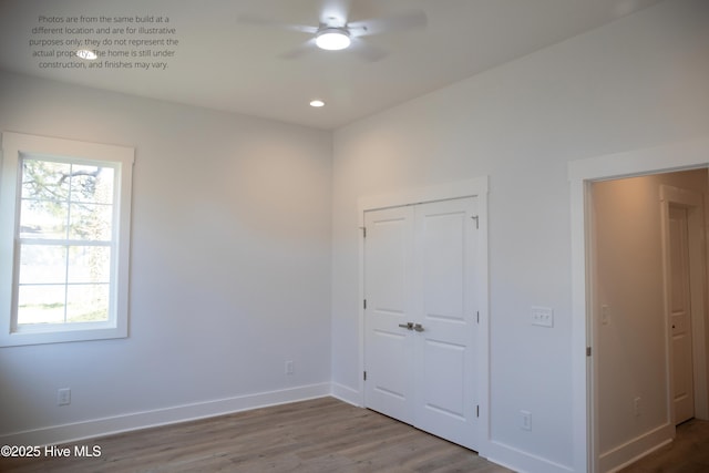 unfurnished bedroom featuring hardwood / wood-style floors, ceiling fan, and a closet