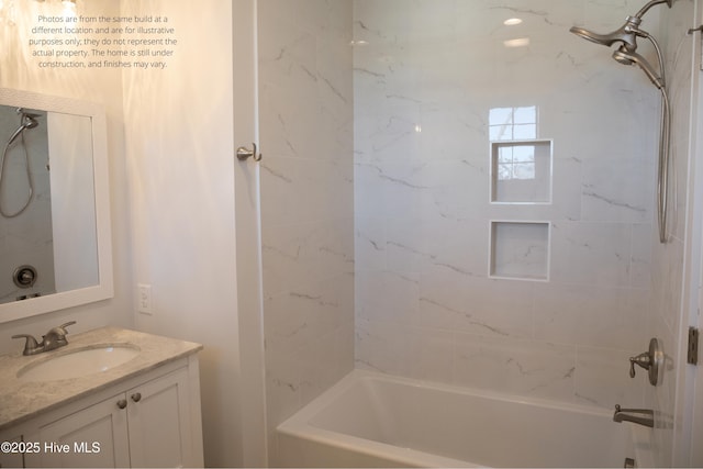 bathroom with tiled shower / bath and vanity