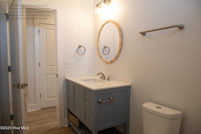 bathroom with vanity, hardwood / wood-style flooring, and toilet