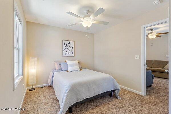 bedroom featuring light colored carpet and ceiling fan