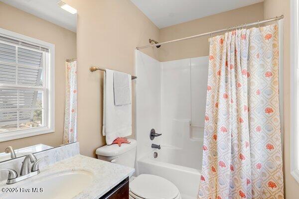 full bathroom featuring vanity, shower / bath combination with curtain, and toilet