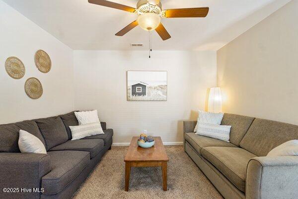 carpeted living room with ceiling fan