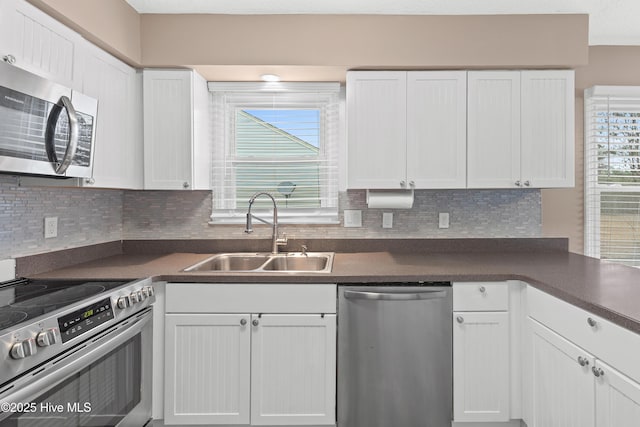 kitchen featuring white cabinetry, appliances with stainless steel finishes, sink, and backsplash