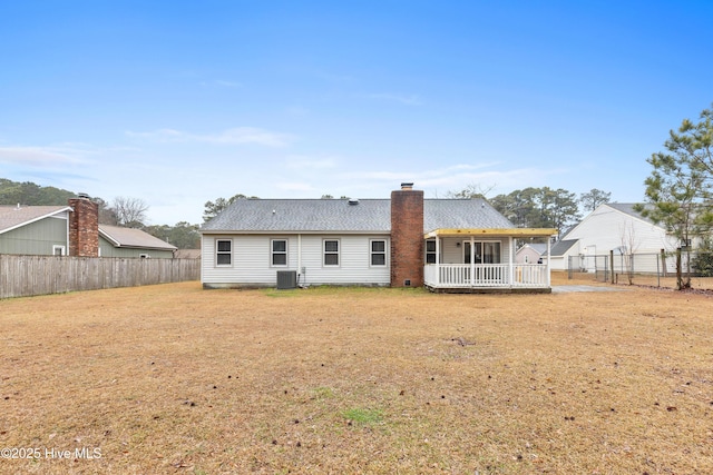 rear view of property with cooling unit and a yard