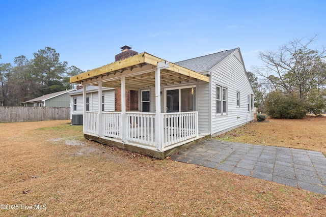 view of front of property with central AC, a front yard, and a deck