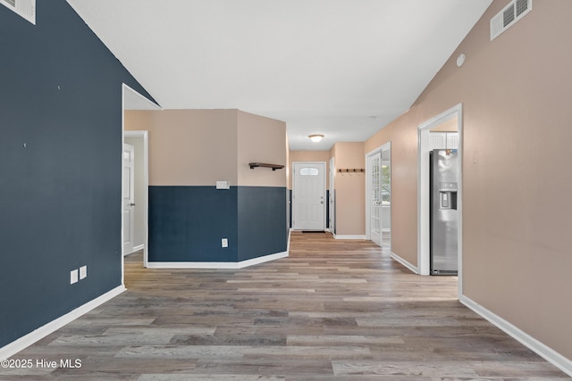 corridor featuring vaulted ceiling and hardwood / wood-style floors